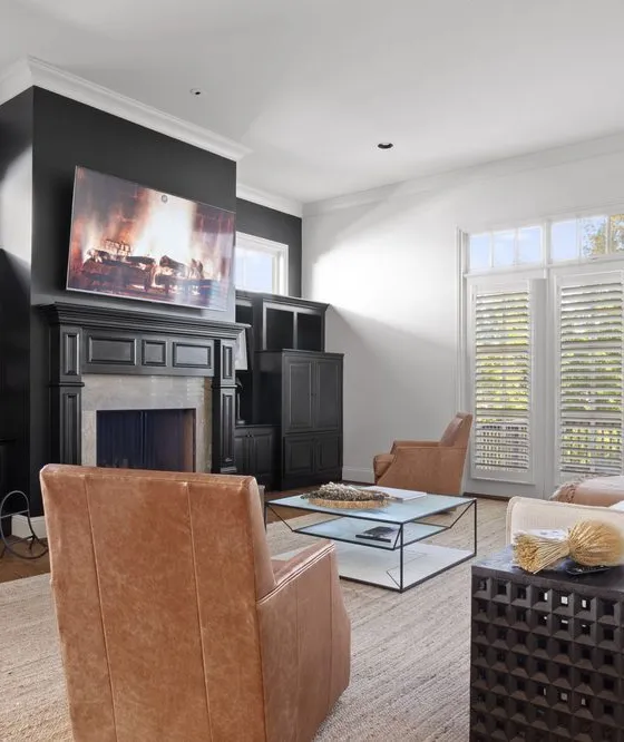 A finished family room with white walls and trim and painted black built-ins